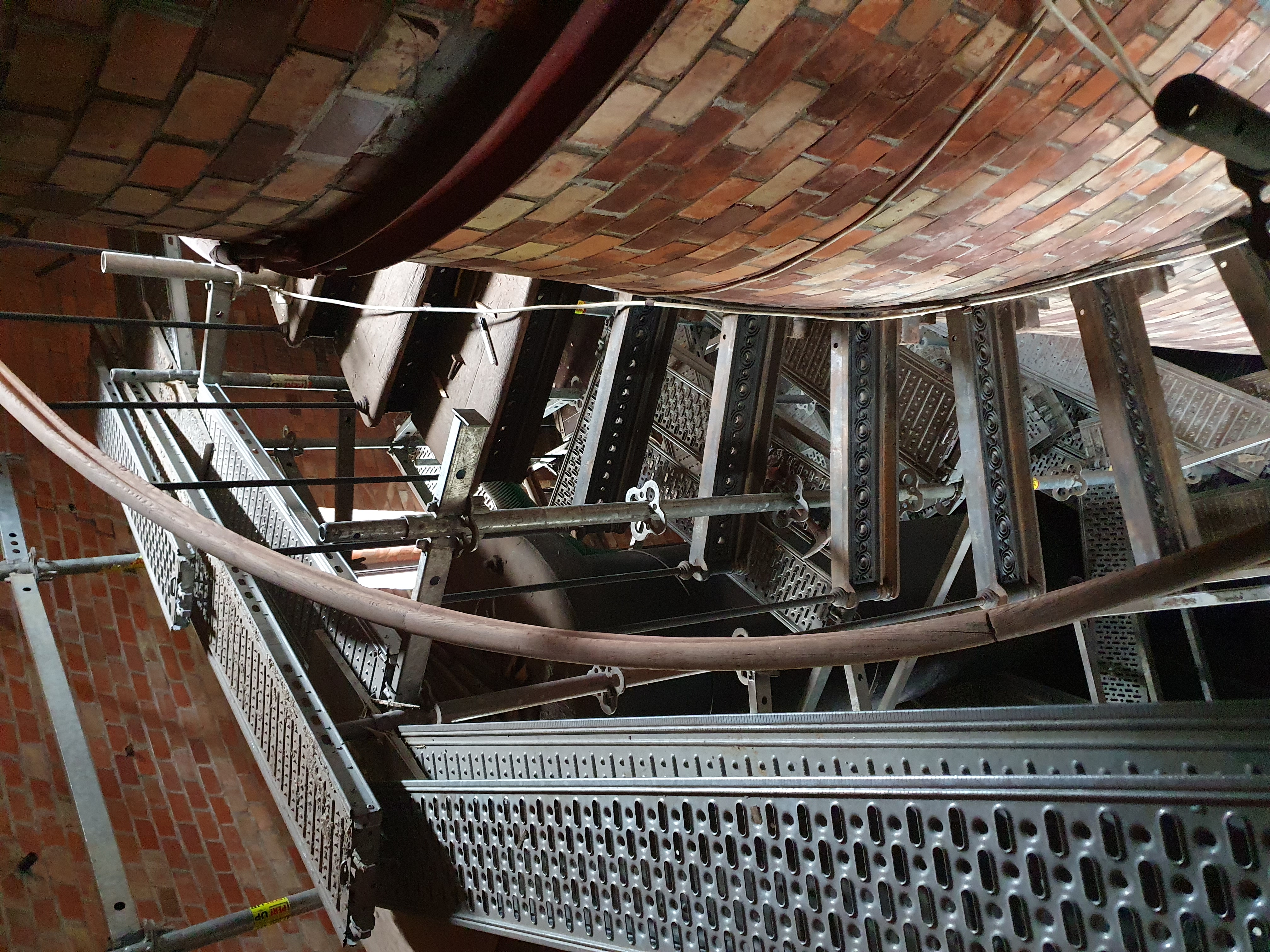 kręcone schody wewnątrz wieży ciśnień, obok schodów elementy rusztowania